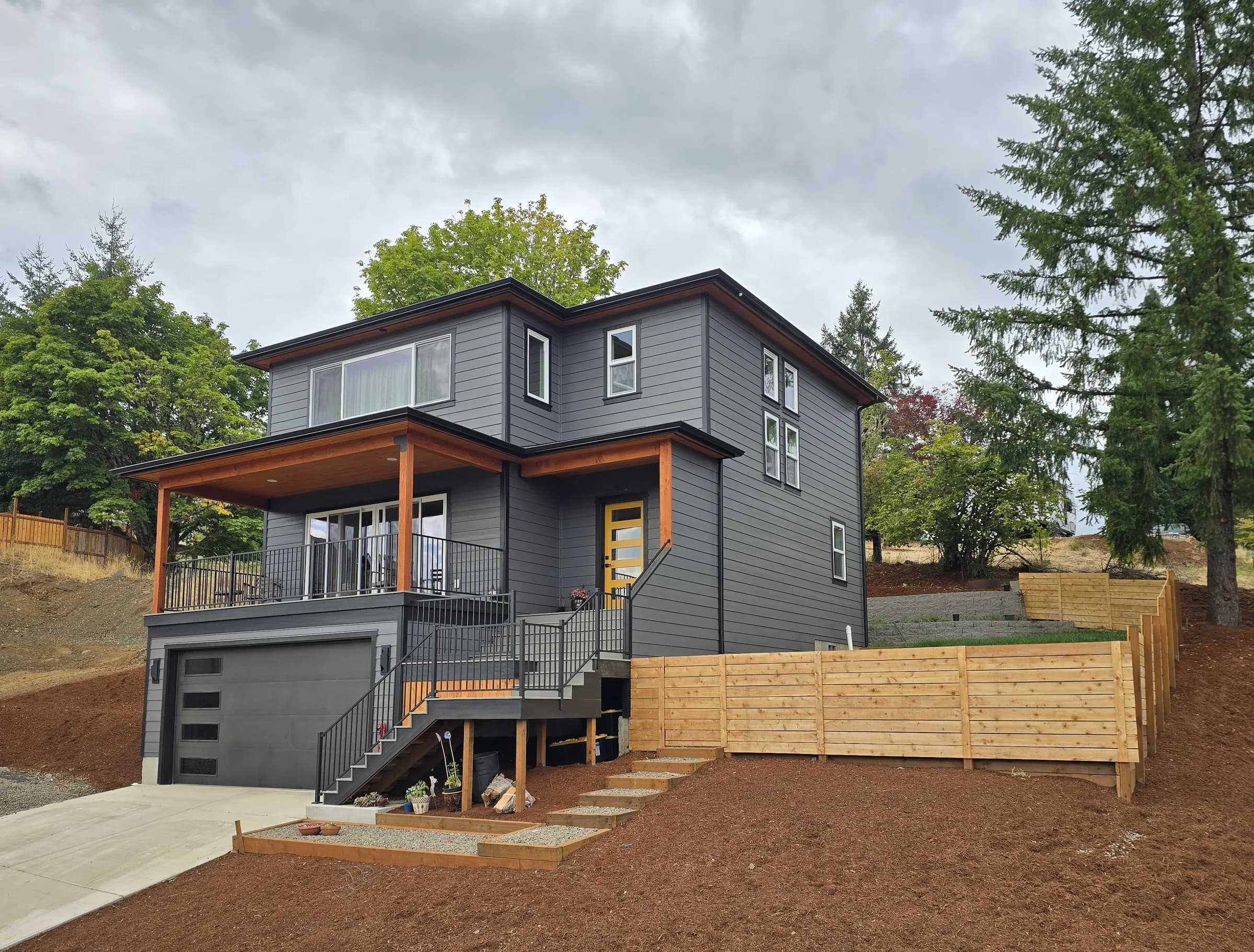 Exterior of the Hillside House, a charcoal two-story home set into a hillside